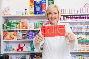 Smiling pharmacist showing envelope at the camera