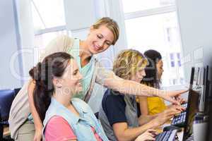 Computer teacher helping female students