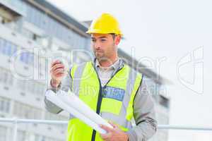 Architect using smartphone against building
