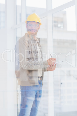 Architect writing on clipboard in office