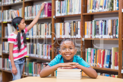 Cute pupils looking for books in library