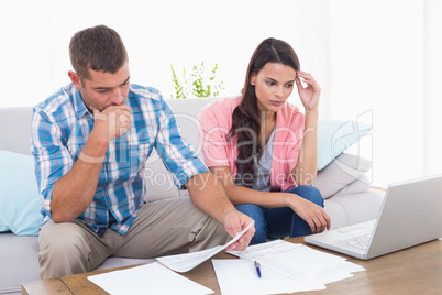 Stressed couple calculating home finances