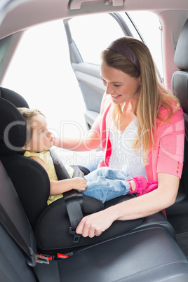 Mother securing her baby in the car seat