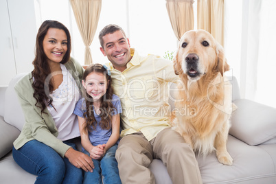 Family sitting with dog on sofa