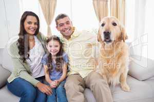 Family sitting with dog on sofa