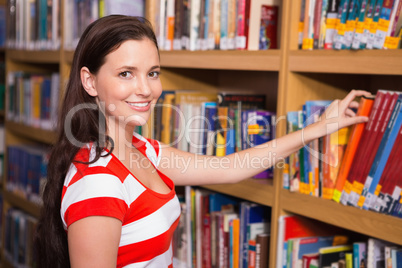 Student covering face with book in library