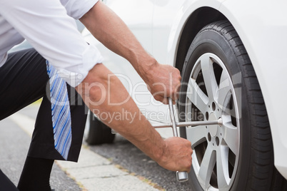 Businessman fixing tire