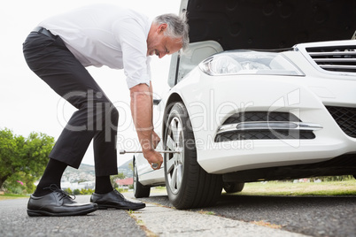 Businessman fixing tire