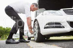 Businessman fixing tire