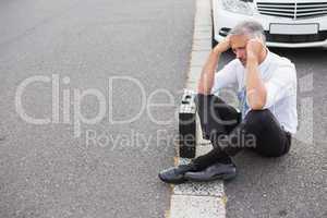 Sad man waiting for assistance after breaking down