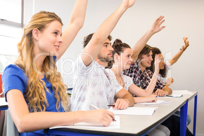 Students raising hands in classroom