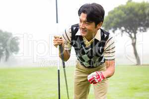 Golfer holding golf ball and club