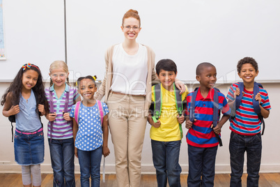 Teacher and pupils smiling at camera in classroom