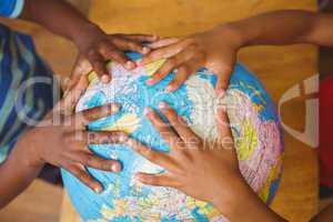 Hands on globe in classroom