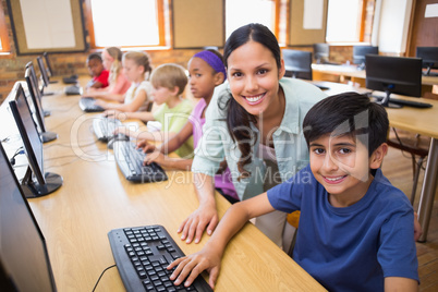 Cute pupils in computer class with teacher