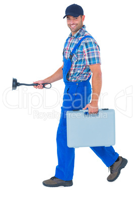 Happy plumber with plunger and toolbox walking on white backgrou