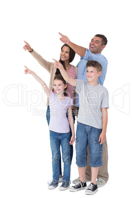 Family of four pointing at copy space