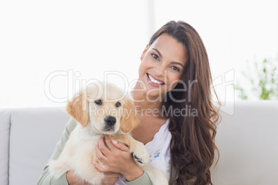 Happy young woman playing with puppy