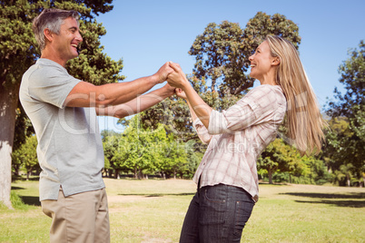 Happy couple dancing in the park