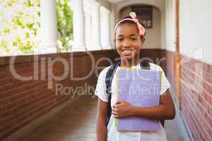 Little girl holding folders in school corridor