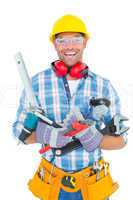 Portrait of smiling manual worker holding various tools
