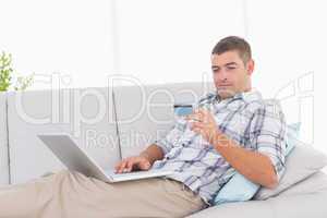Man shopping online through laptop using credit card