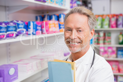 Senior pharmacist holding documents