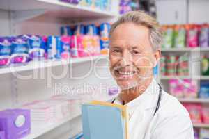 Senior pharmacist holding documents