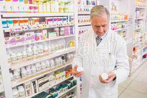 Smiling pharmacist looking at medications
