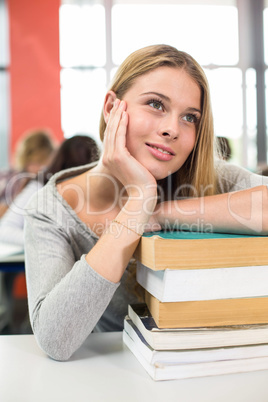 Thoughtful student with books in classroom