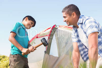 Father and son pitching their tent
