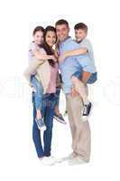 Parents giving piggyback ride to children over white background