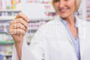 Smiling pharmacist showing calling card