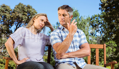 Couple having an argument on park bench