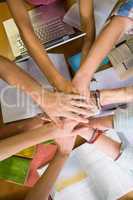 Students placing hands together over library table