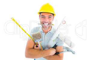 Portrait of smiling handyman holding various tools