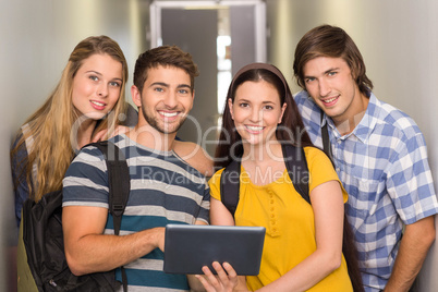 Students using digital tablet at college corridor