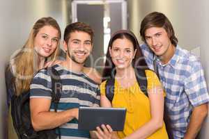 Students using digital tablet at college corridor