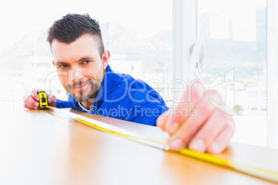 Handyman measuring wood board