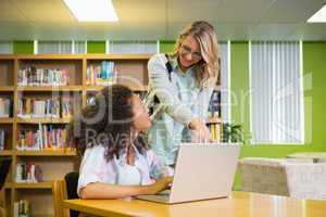 Student getting help from tutor in library