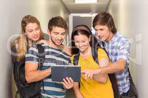 Students using digital tablet at college corridor