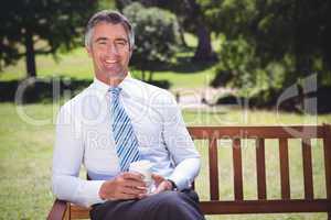 Businessman having coffee in the park