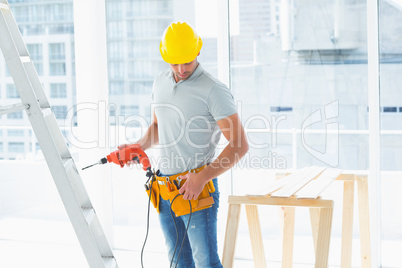 Repairman with drill machine in building