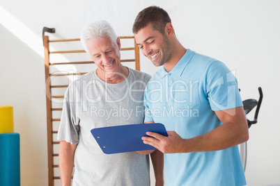 Senior man with coach looking at clipboard