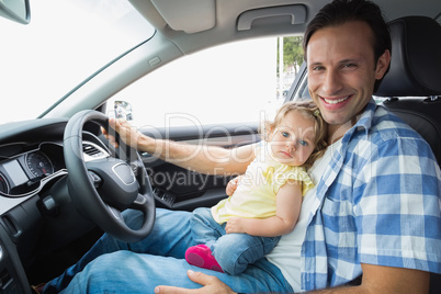 Father playing with baby in drivers seat