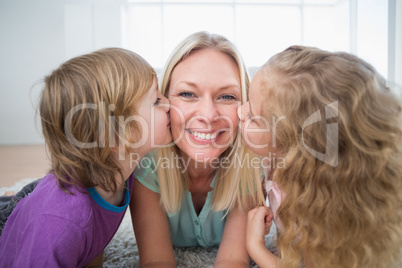 Happy woman being kissed by children
