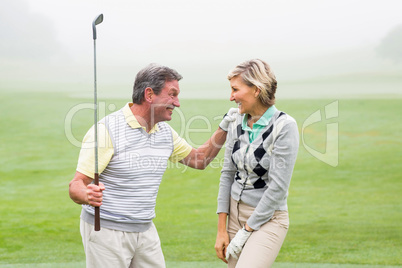 Excited golfing couple cheering