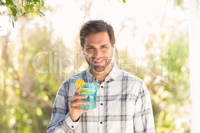 Happy man smiling at camera with drink