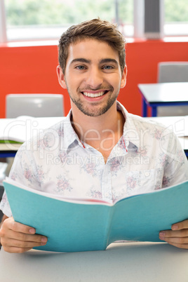 Male student reading notes in classroom