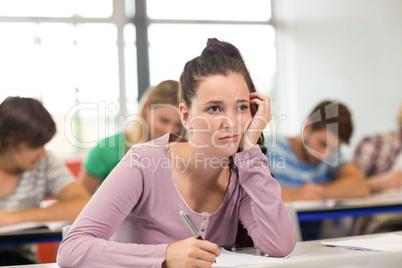 Female student writing notes in classroom